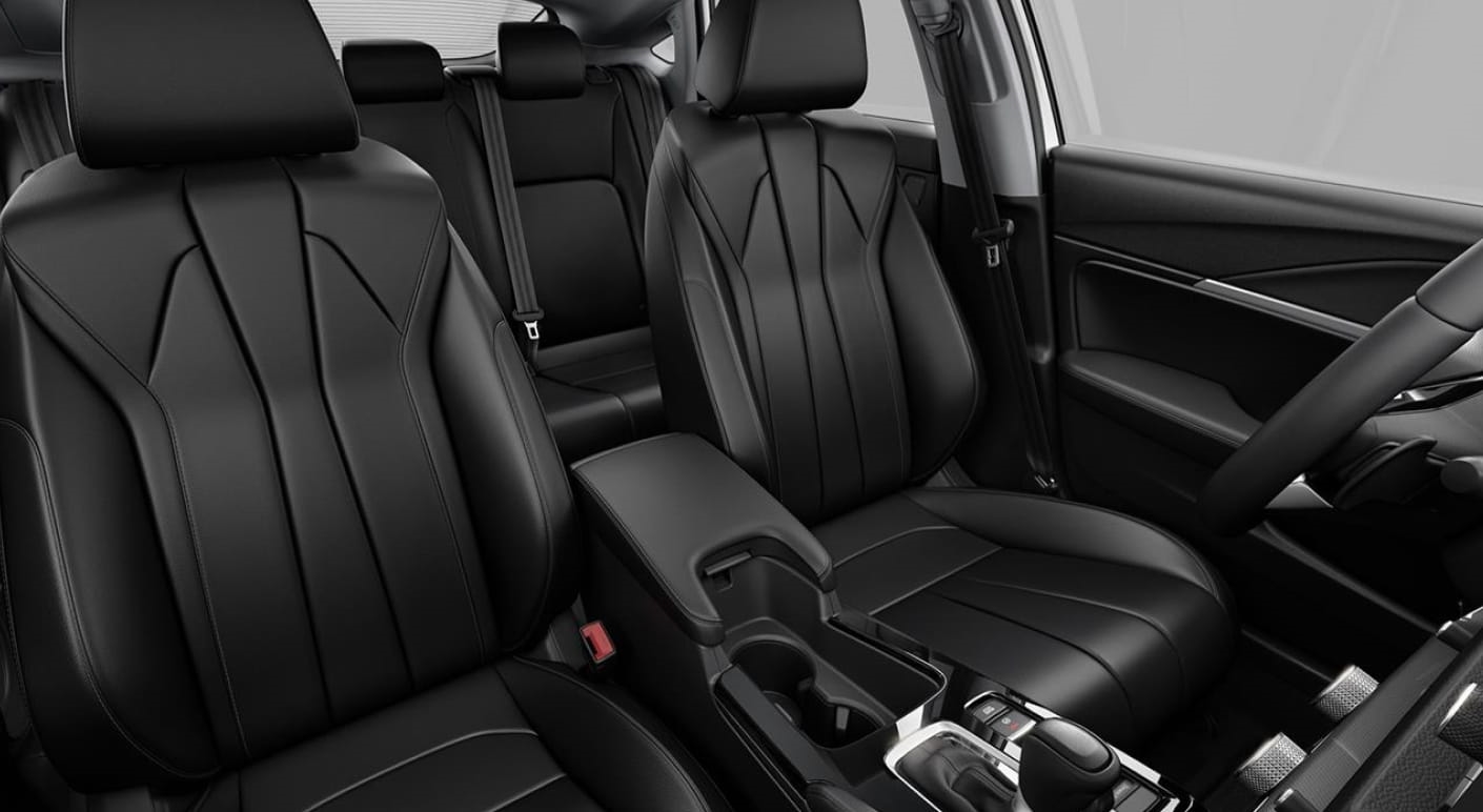 Acura Integra interior featuring black leather front seats, a center console with cupholders, and the rear seating area.