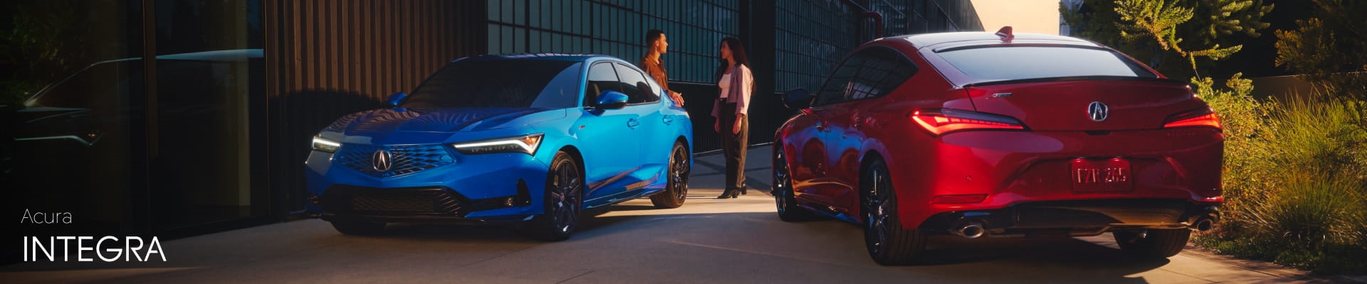 Acura Integra - Blue and red Acura Integra models parked outside a modern building at sunset with two people talking in the background.