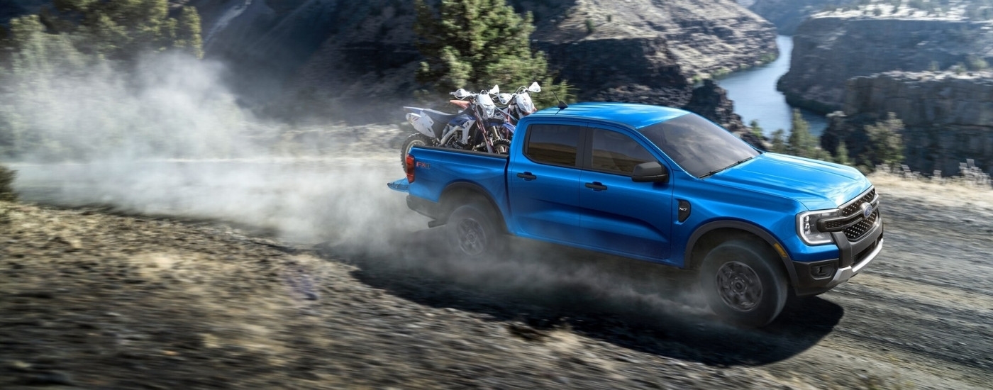 Blue 2026 Ford Ranger XLT hauling two dirt bikes