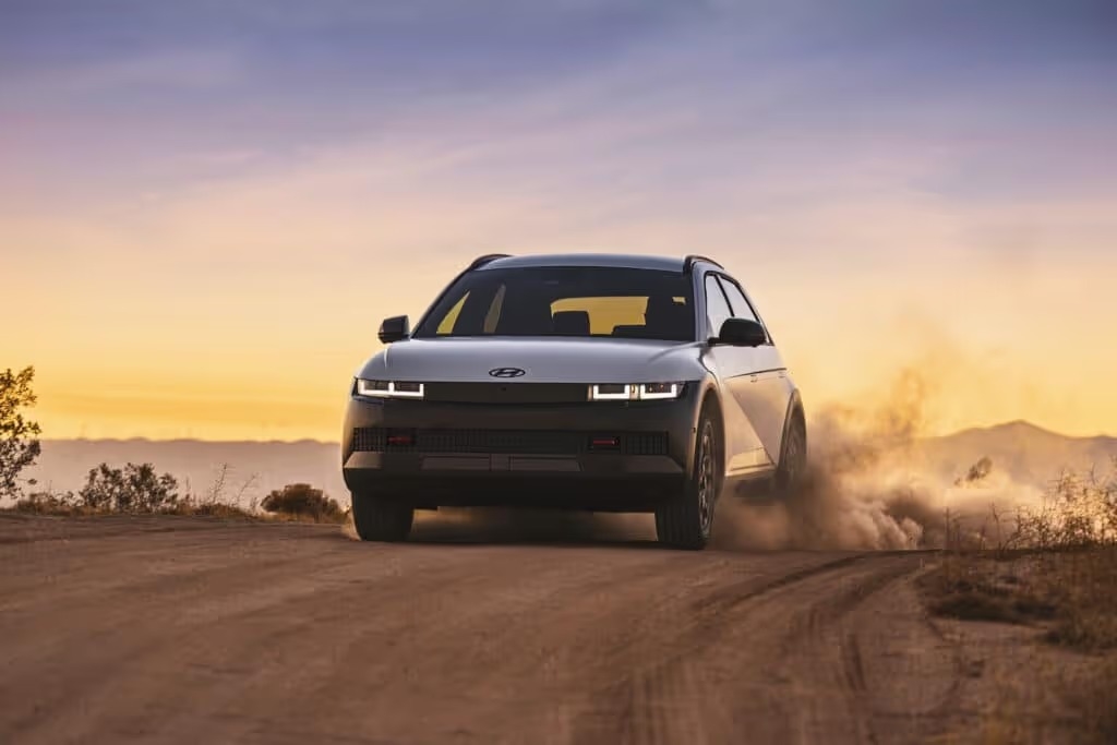 A 2025 IONIQ 5 XRT navigating a rugged dirt road, showcasing its versatility and off-road capability.
