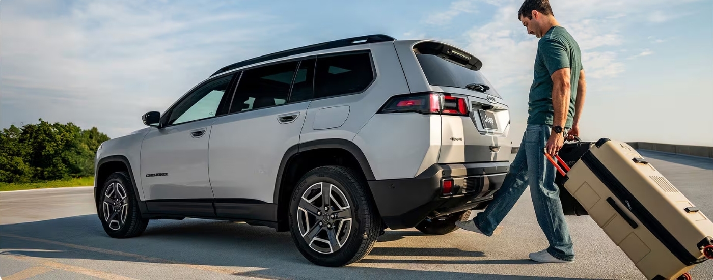 Person carrying luggage near a 2026 Jeep Cherokee