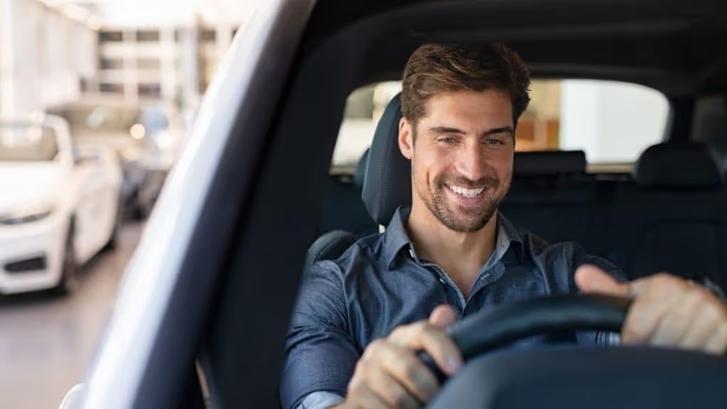 a gentlemen inside a vehicle he is about to test drive performing his own personal vehicle internal inspection before leaving