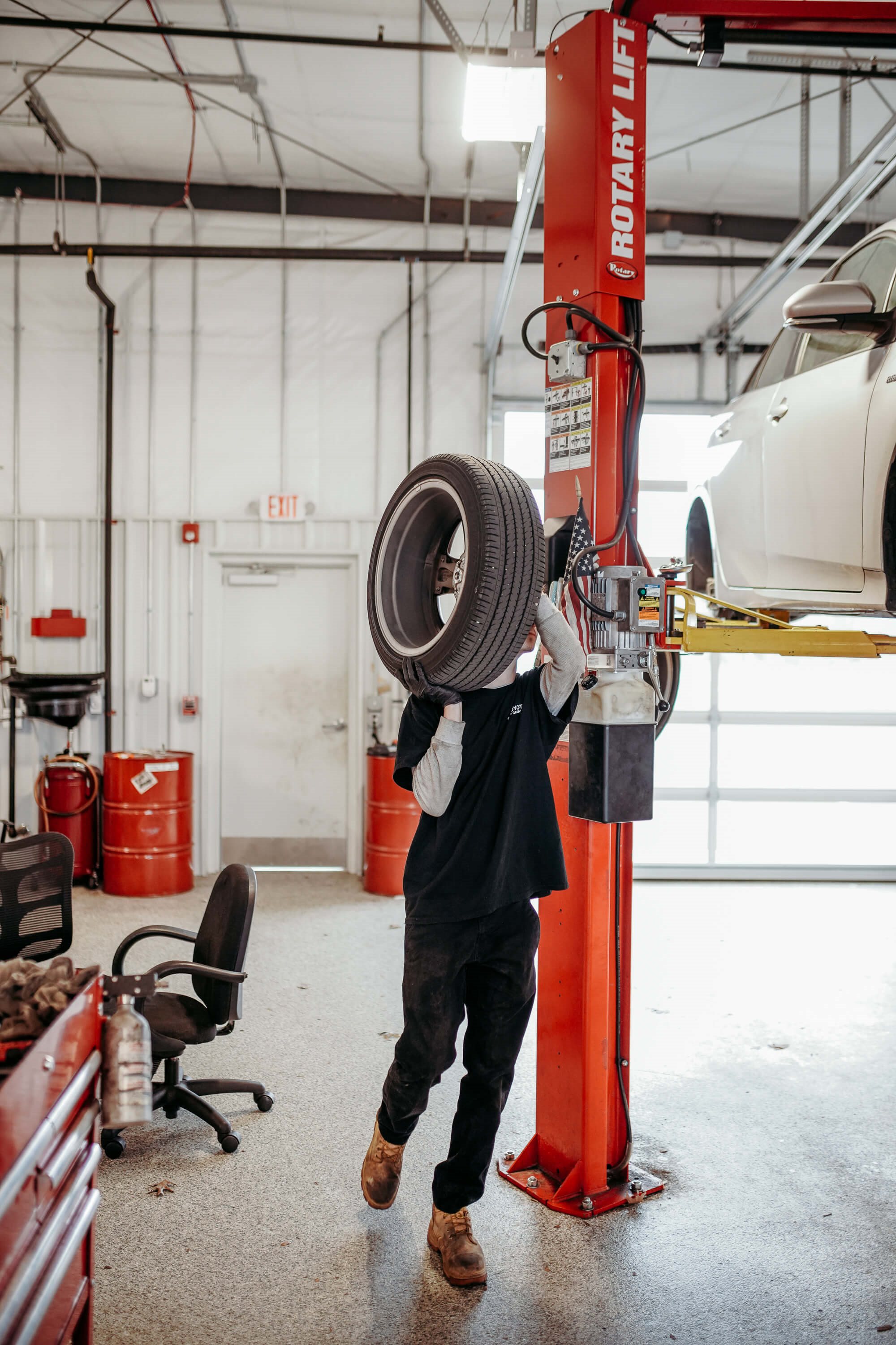 Toyota of Gallatin technician carrying a tire inside the Gallatin service center