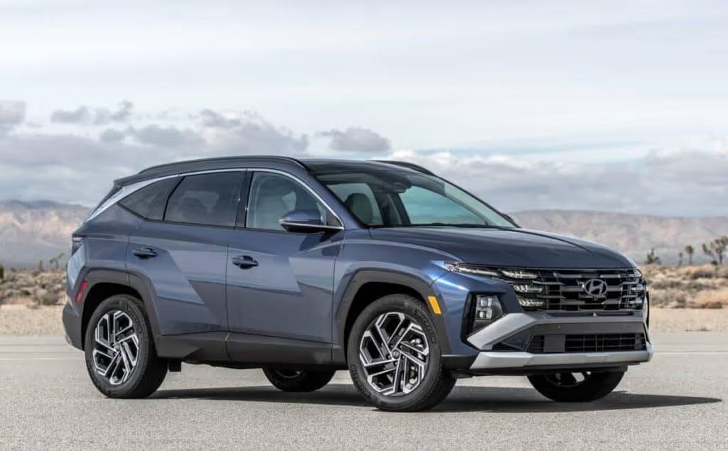 A blue 2024 Hyundai TUCSON parked in front of rolling hills