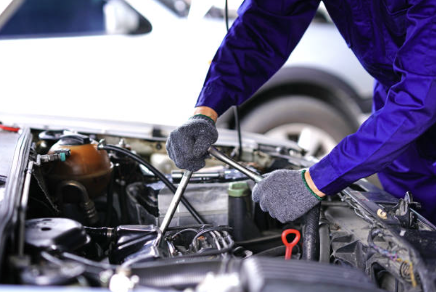Technician inspecting vehicle underside