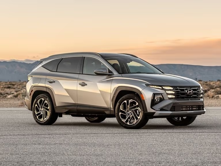 a blue 2025 tucson hybrid parked in front a sprawling mountainscape