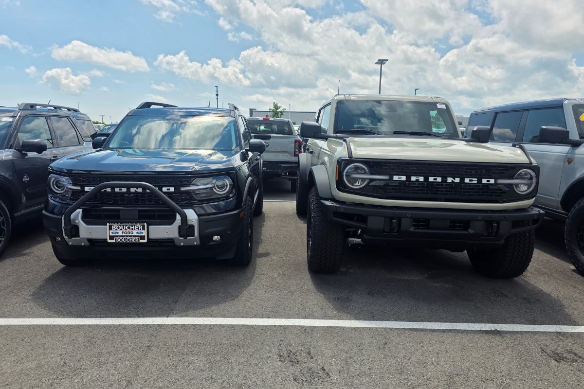 Ford Bronco and Ford Bronco Sport parked side by side at Boucher Ford Kenosha, comparing the height, width, and overall size of the two SUVs.