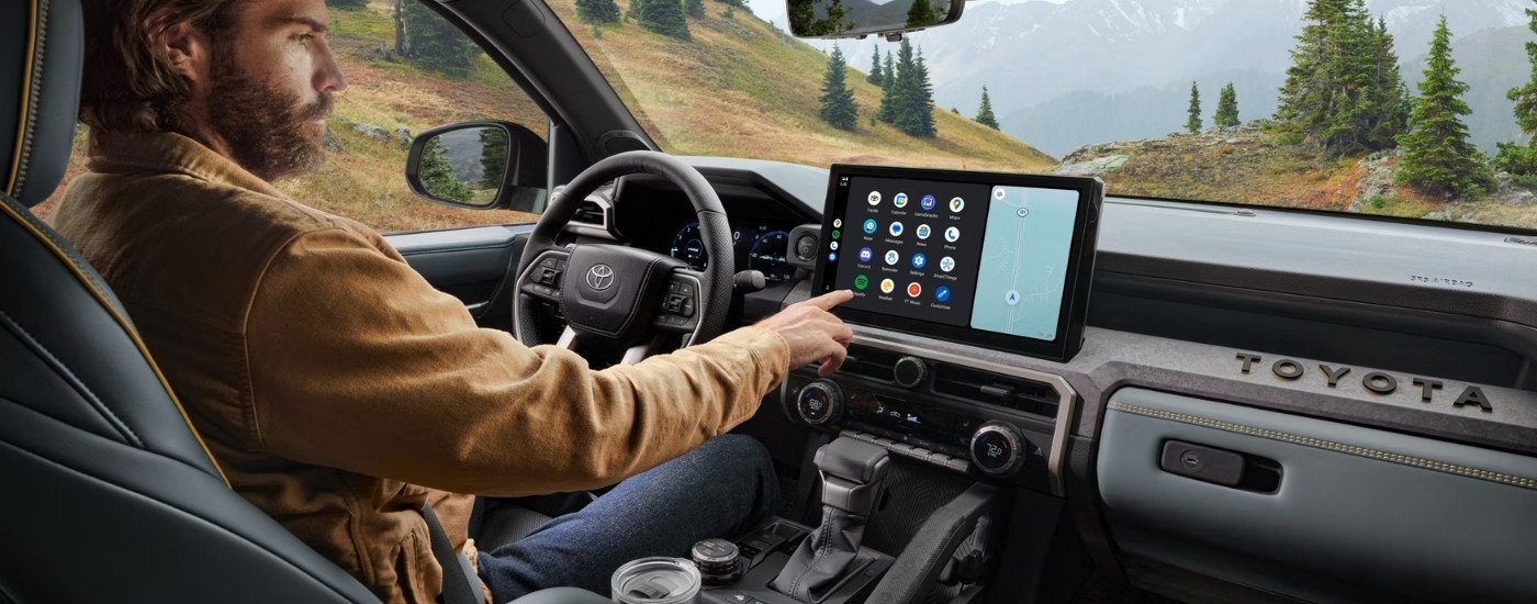 Person using the infotainment screen in a 2025 Toyota Tacoma