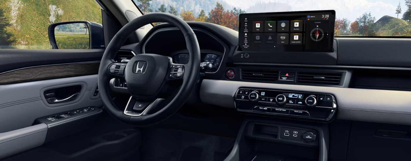 Interior view of a 2026 Honda Pilot infotainment display and steering wheel.