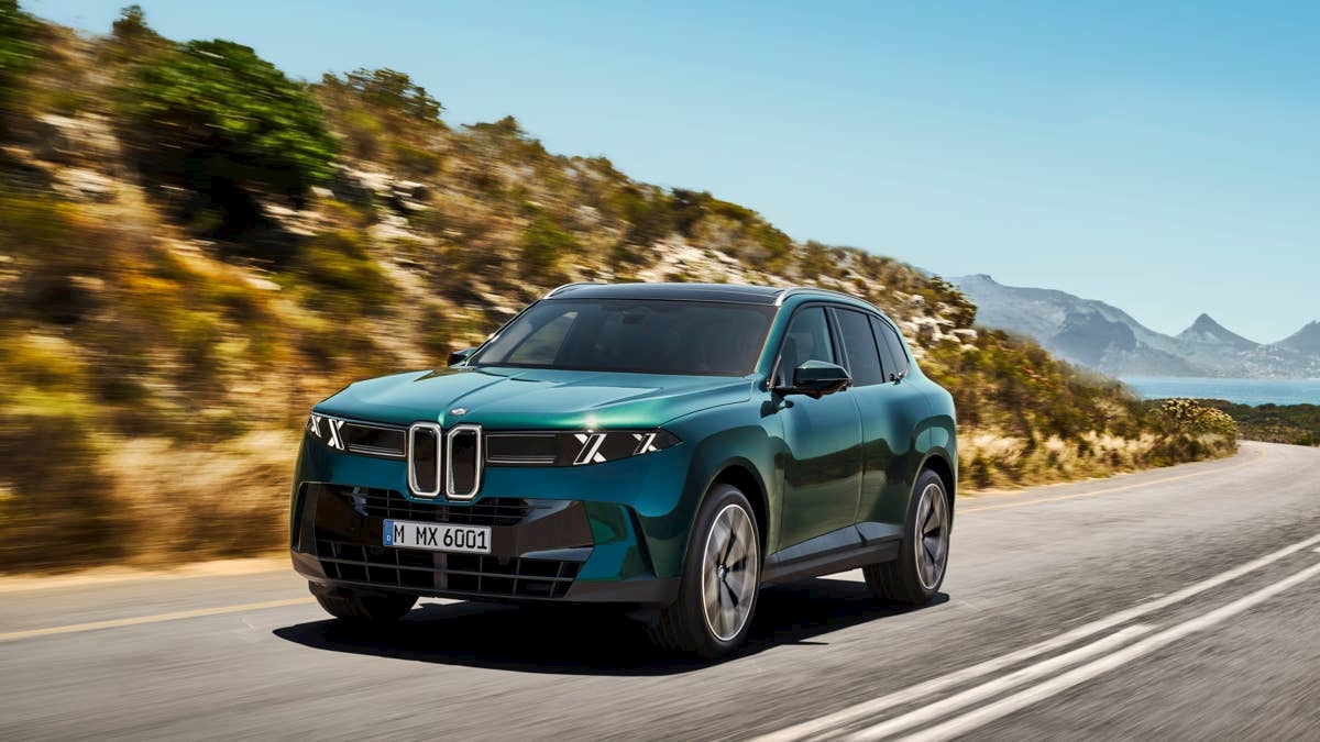 2027 BMW X5 in green driving on a coastal road, one of the new BMW models available to reserve at BMW of Darien