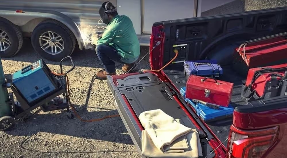 A person is shown welding near a 2024 Ford F-150 Lariat.