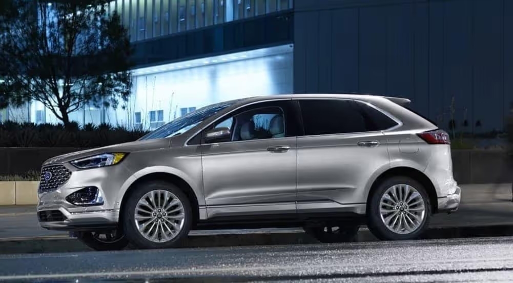 A silver 2024 Ford Edge is shown parked at night.