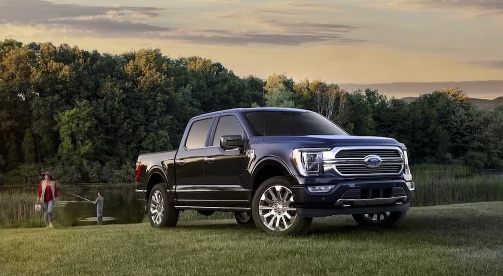 A dark blue 2023 Ford F-150 XLT is shown parked near a lake after viewing a Ford F-150 for sale in Shelbyville.