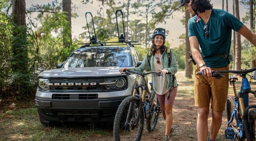 Bikers are shown near a silver 2023 Ford Bronco Sport Outer Banks on a trail.