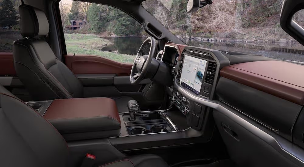 The brown interior of a 2023 Ford F-150 is shown from the passenger seat.