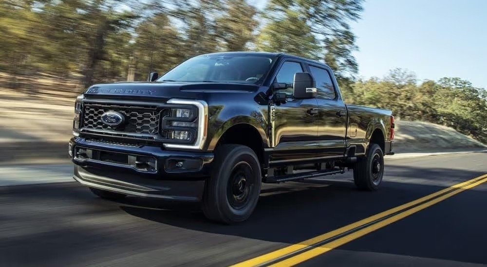 A black 2023 Ford F-250 XL STX is shown driving on a highway after viewing super duty trucks for sale near Murfreesboro.