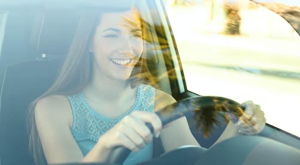 A teen is shown driving a vehicle.
