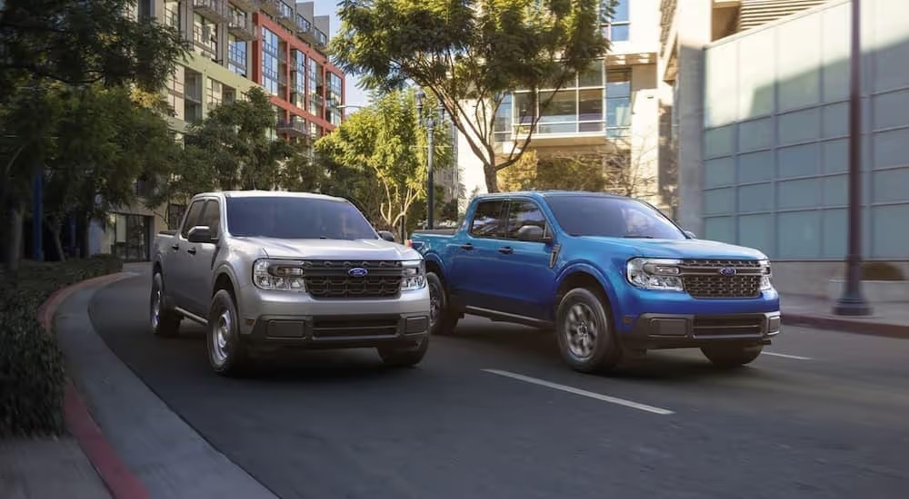 A grey and blue 2022 Ford Maverick are shown driving on a city street.