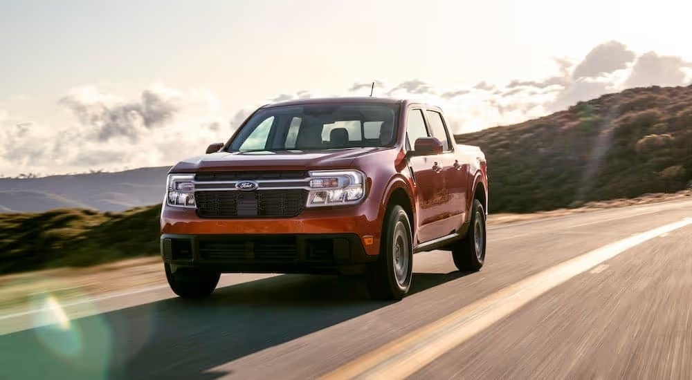 A red 2022 Ford Maverick Lariat is shown driving on a sunny day after visiting a Lynchburg Ford dealership.