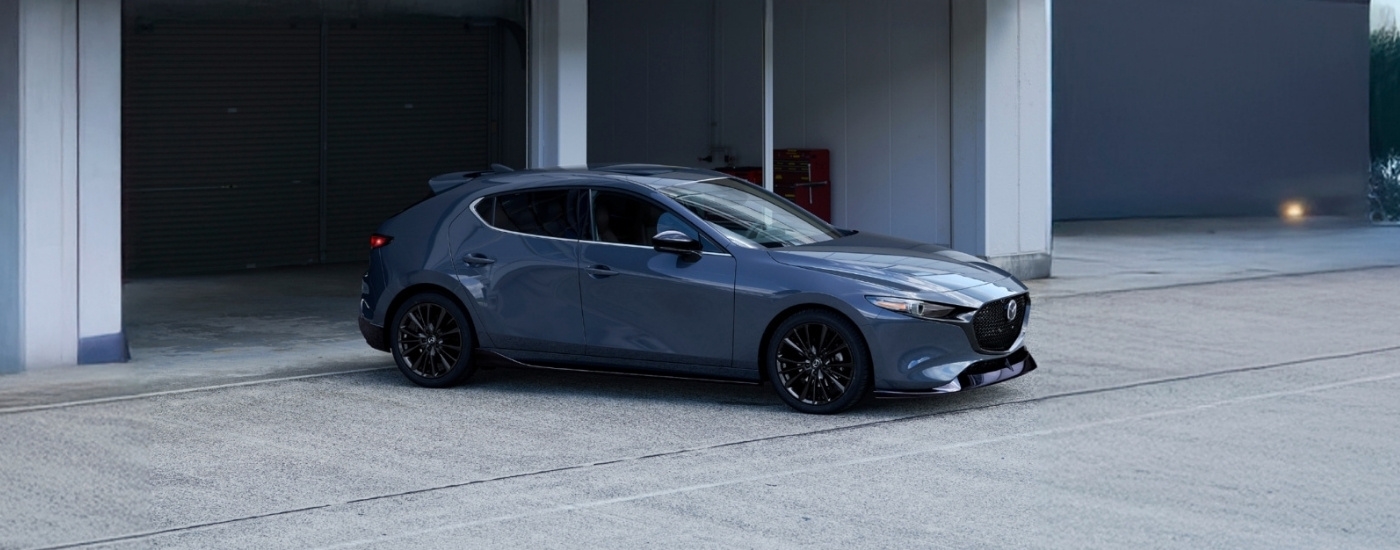 Grey 2026 Mazda3 parked near a garage