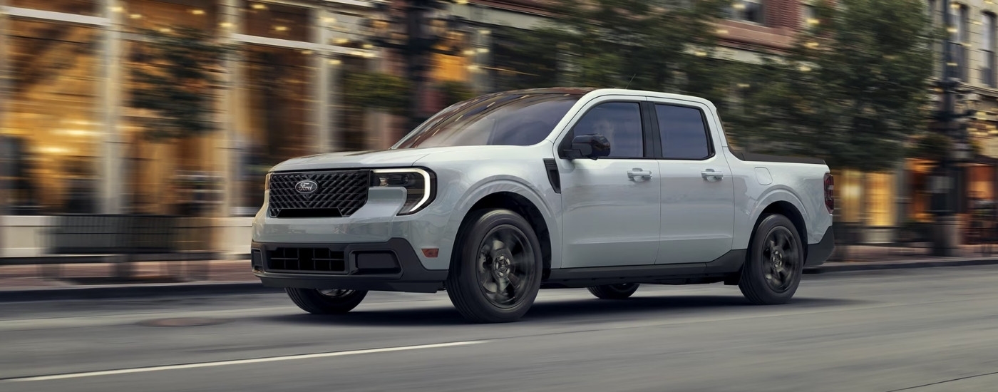 White 2026 Ford Maverick driving in a city.