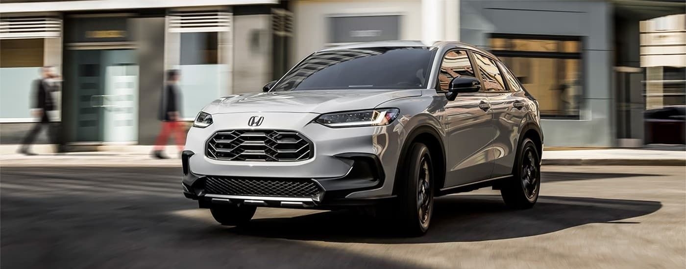 A silver 2023 Honda HR-V Sport with a blurred street background.