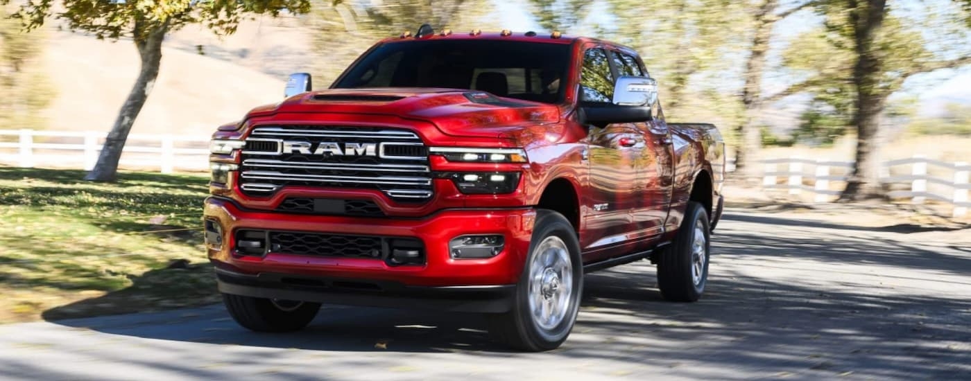 Red 2026 Ram 2500 driving down a road.