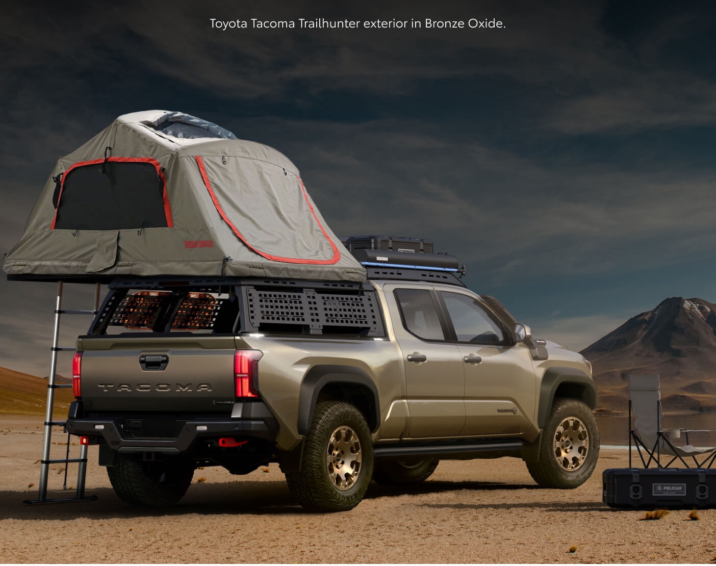 Rear-quarter view of a Bronze Oxide Toyota Tacoma Trailhunter with a rooftop overland tent.