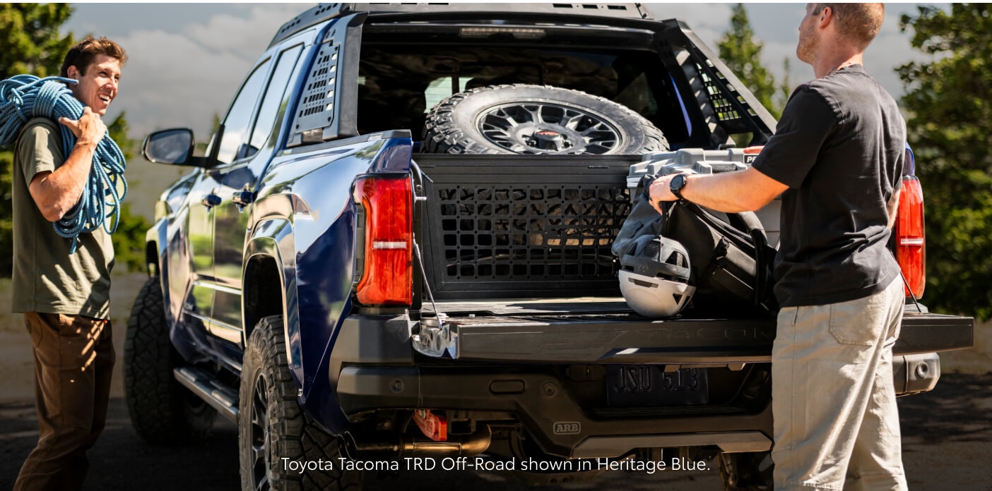 Rear-angle view of a Blue Crush Metallic Toyota Tacoma TRD Off-Road being loaded with outdoor gear.