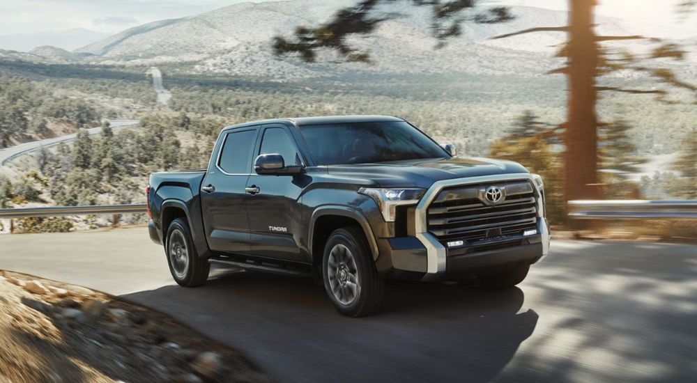 A gray 2026 Toyota Tundra Limited CrewMax driving a mountain-lined road.