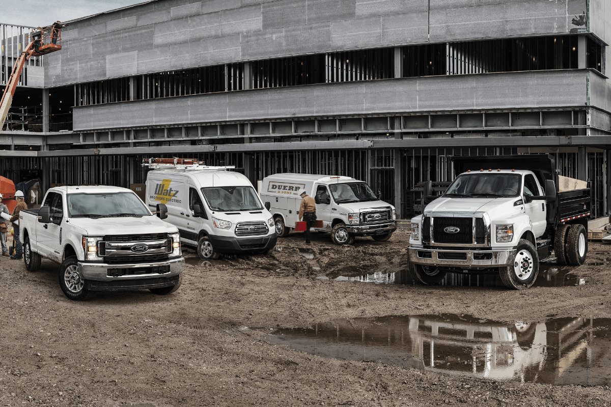 Ford commercial trucks, vans, and work vehicles at a construction jobsite