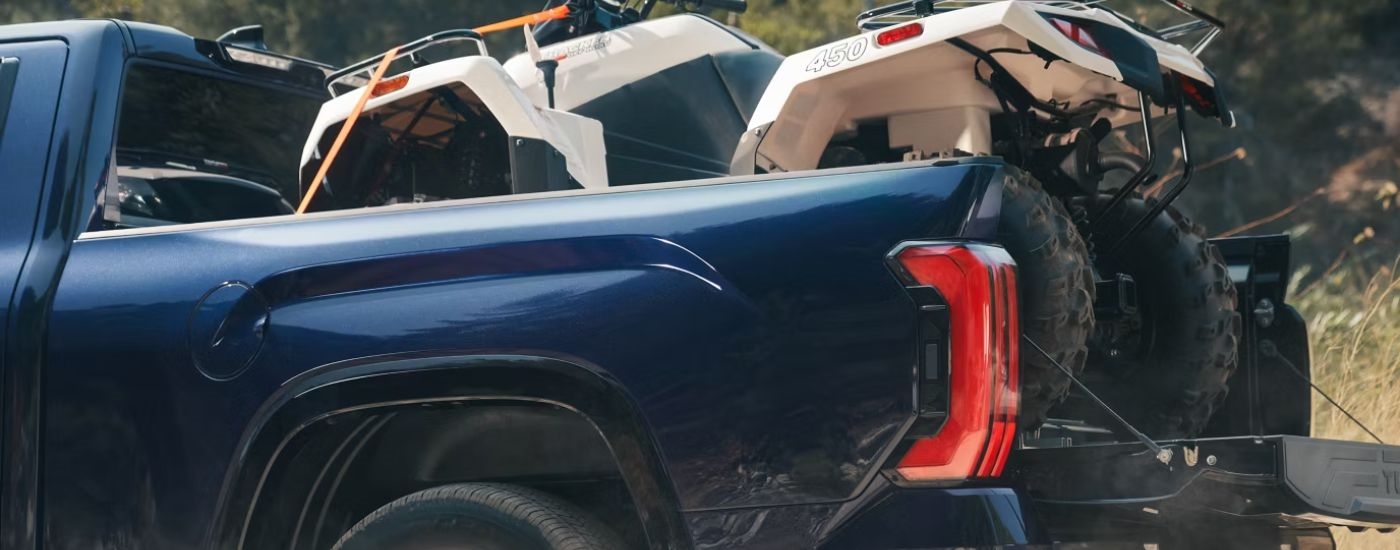 The bed of a blue 2026 Toyota Tundra with an ATV in it.
