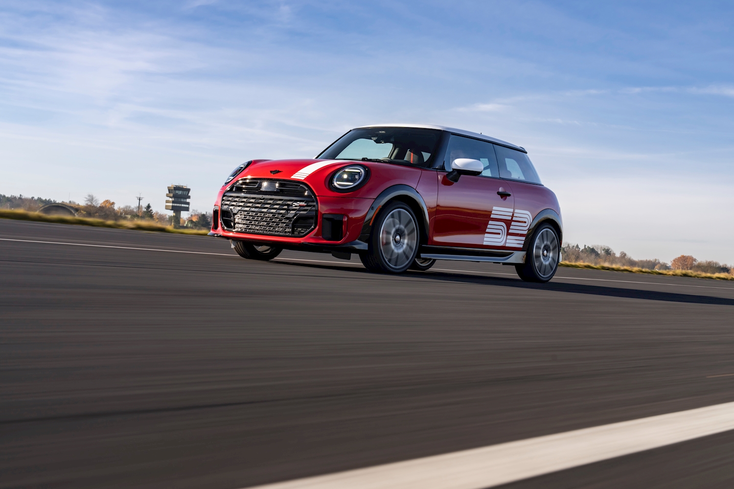 MINI John Cooper Works 1965 Victory Edition in Chili Red with white rally stripes and 52 graphic on a track, available to reserve at MINI of Darien in Connecticut