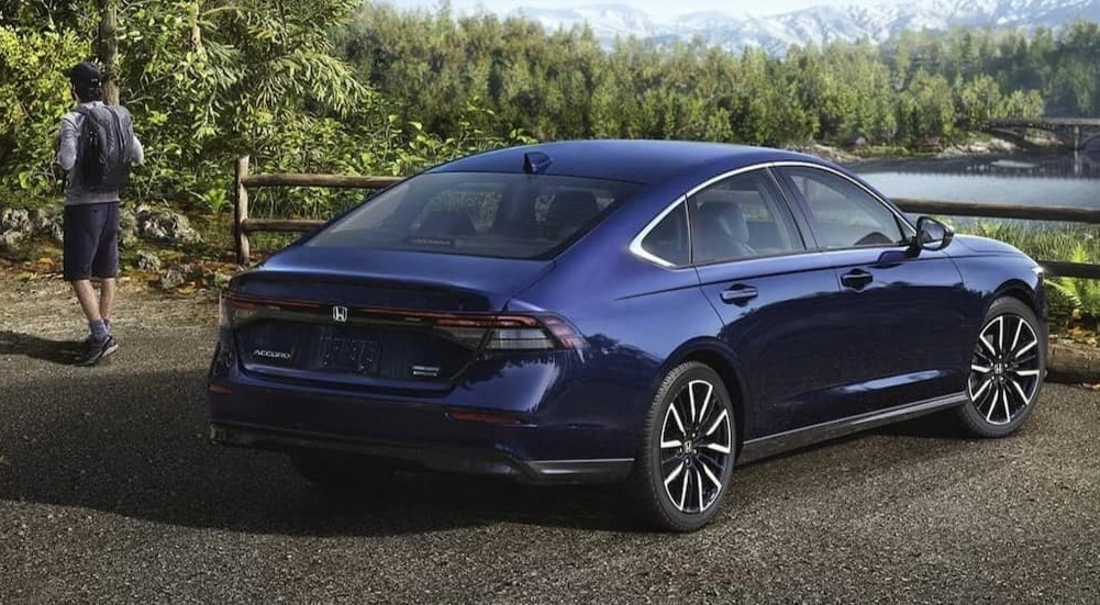 A blue 2026 Honda Accord parked near a hiker.