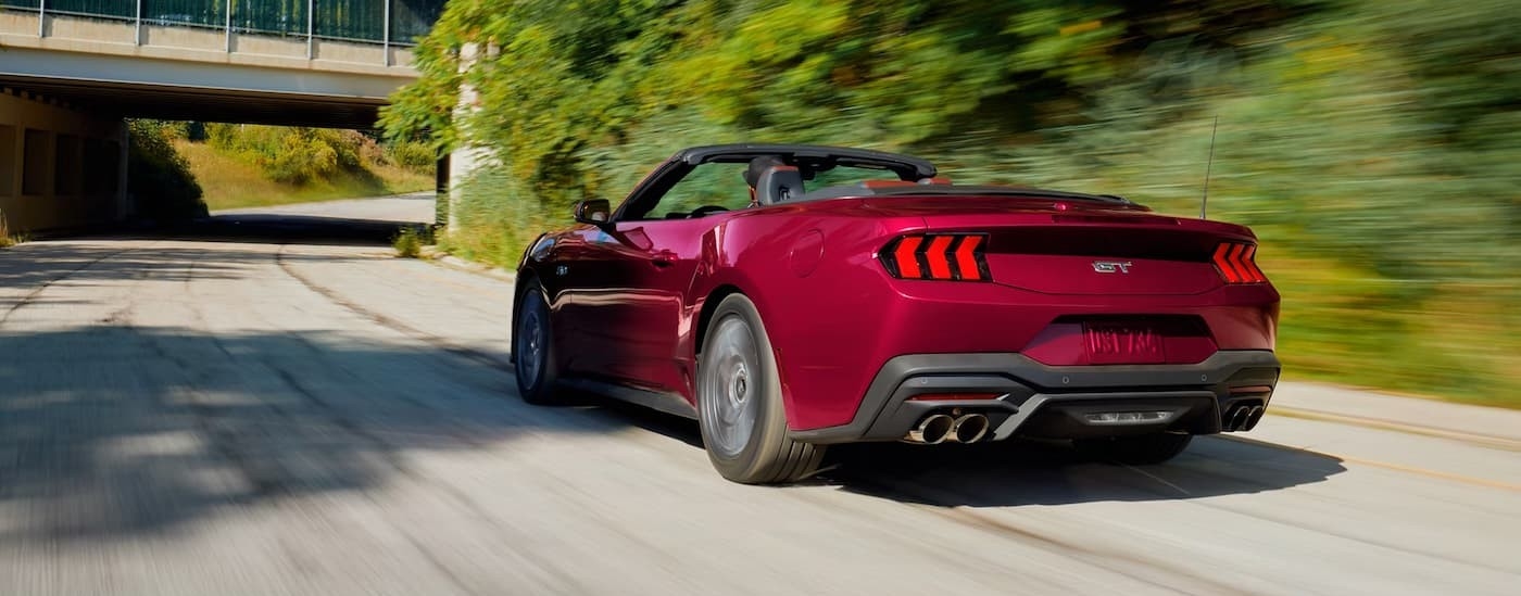 A red 2026Ford Mustang GT driving on a highway.