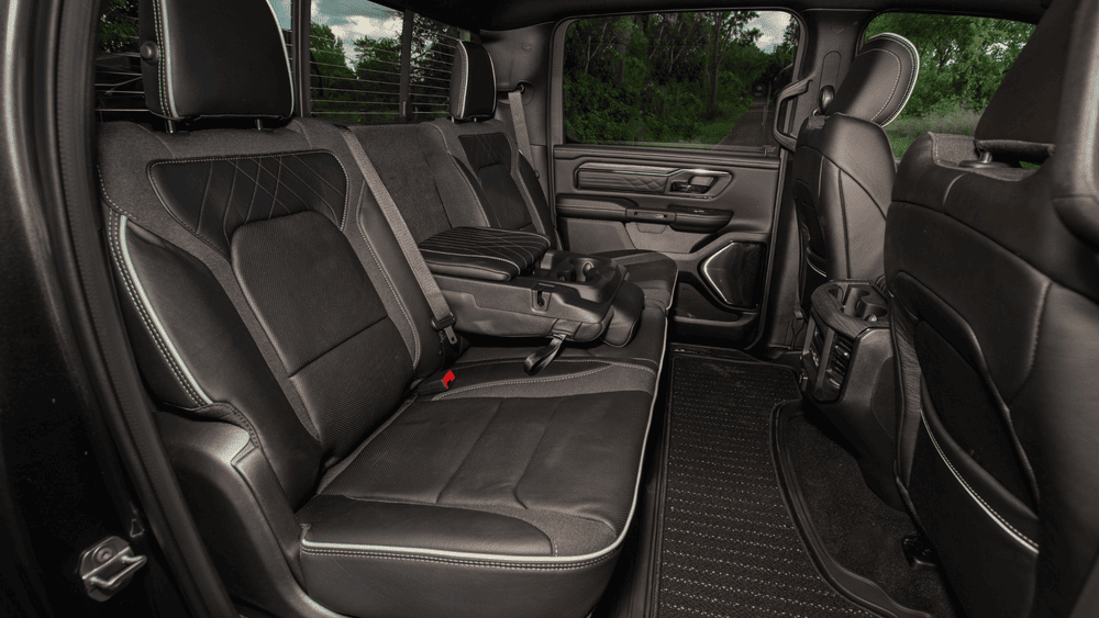 2026 Ram 1500 Rebel rear cab seating in Margate FL with black cloth and leather seats, diamond-stitch pattern, fold-down center armrest, and rear floor-mounted air vents