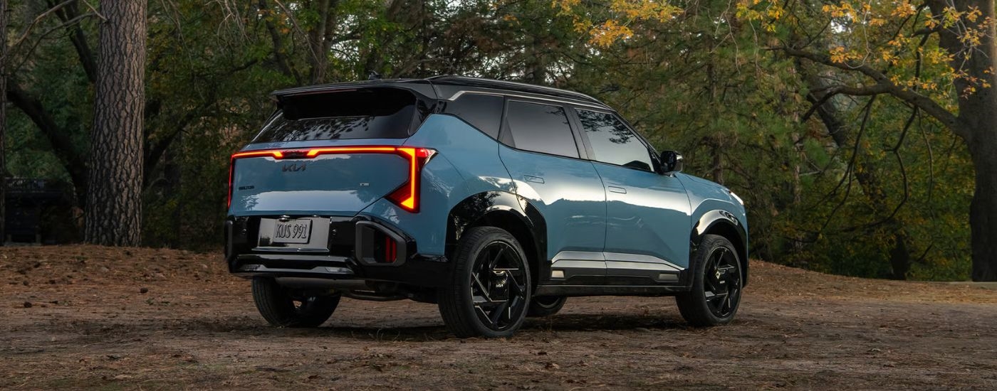 A blue 2027 Kia Seltos X-Line SX parked in a forest.
