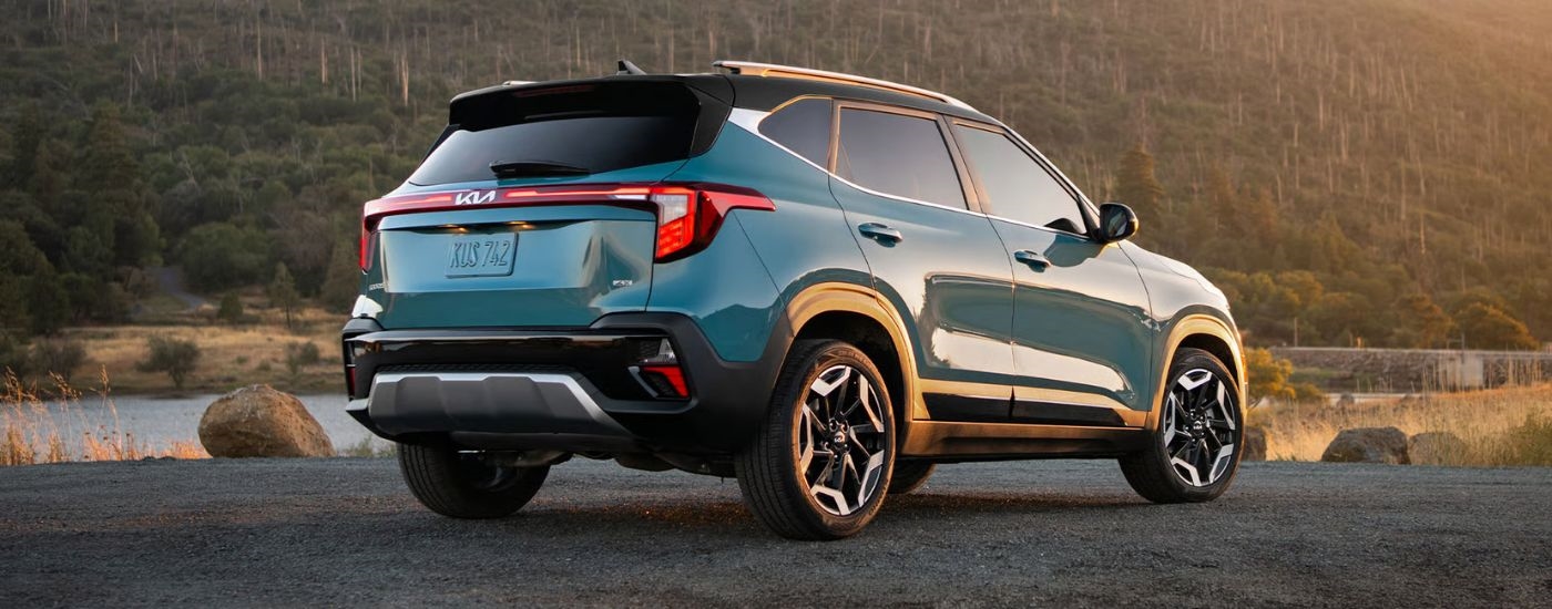Rear viw of a blue 2026 Kia Seltos parked near a body of water.