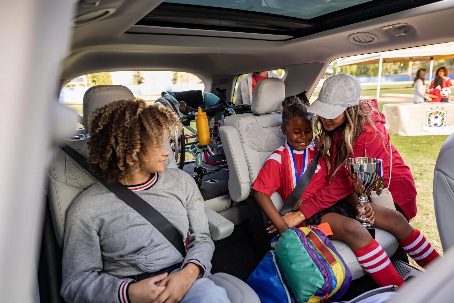 A parent helping children into the rear seats of a 2026 Ford Explorer