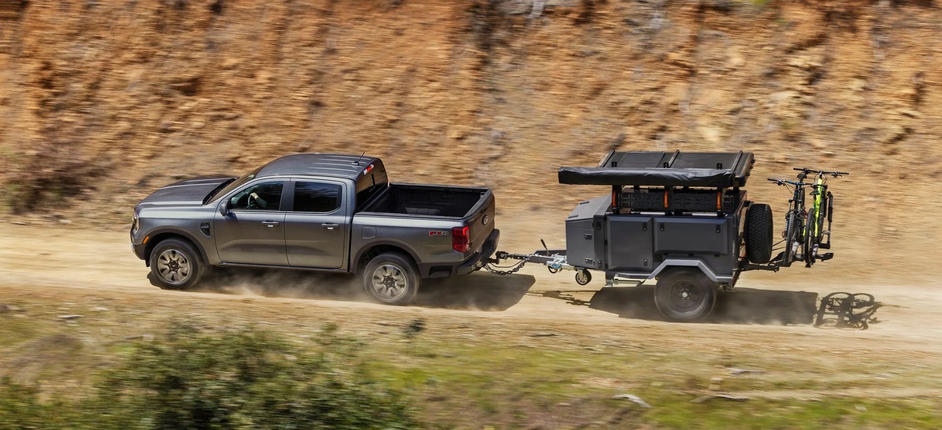 Ford Ranger towing a trailer on a dirt road, the midsize truck option near Oak Grove KY
