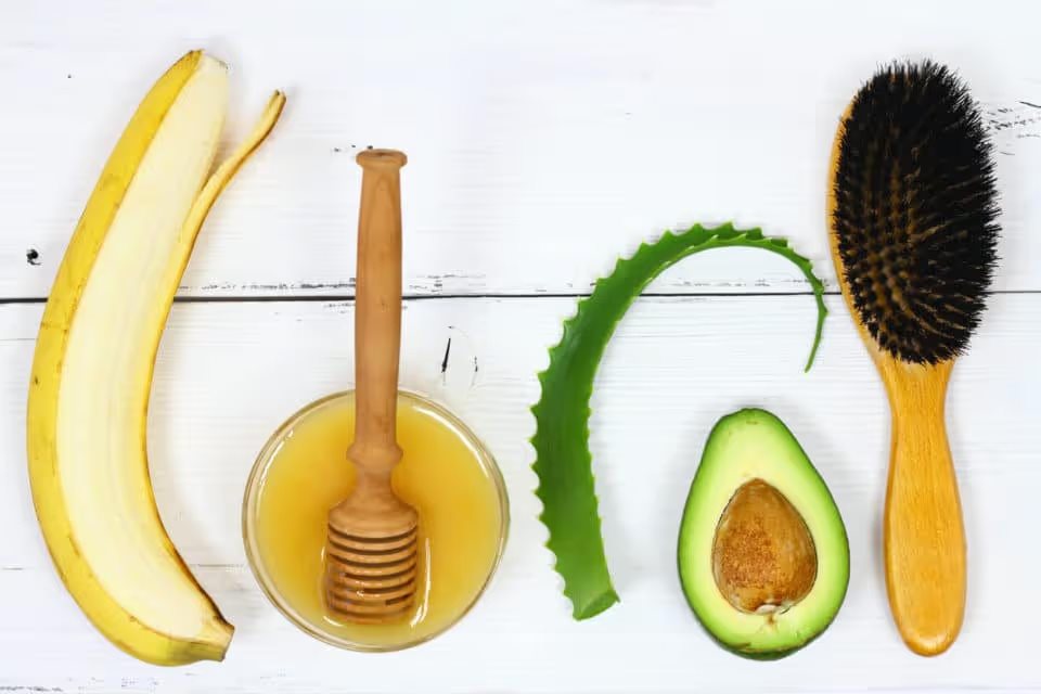 Ingredients for hair mask banana, honey, aloe and avocado on the white board, top view