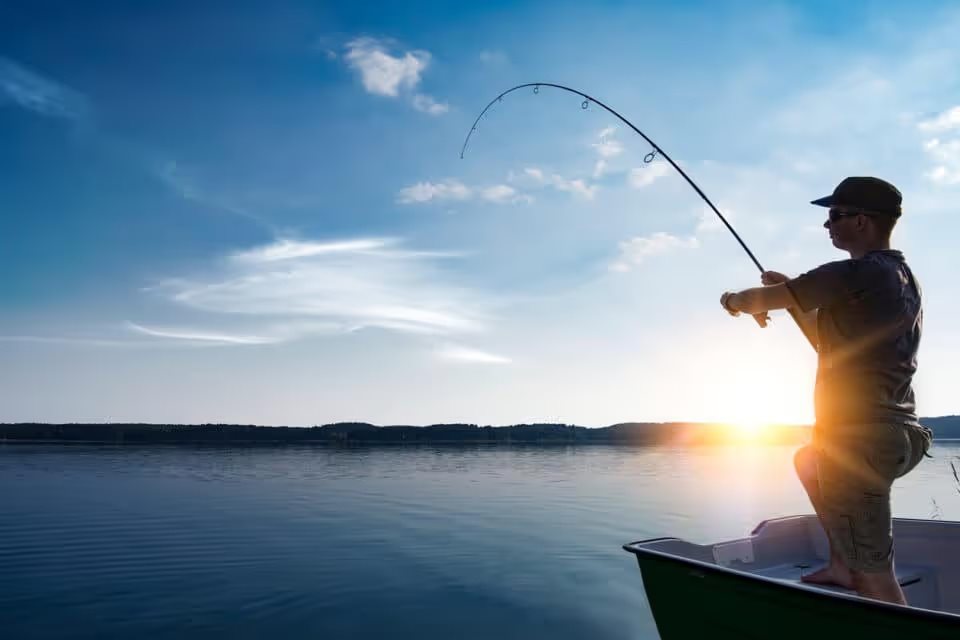 man fishing on lake at sunrise