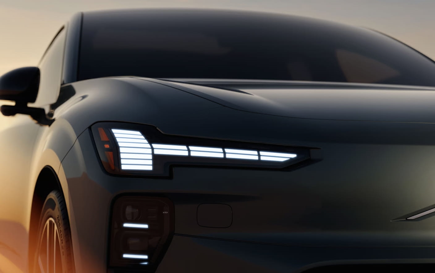 Close-up of a Volvo EX60 front end highlighting the illuminated LED headlight design.