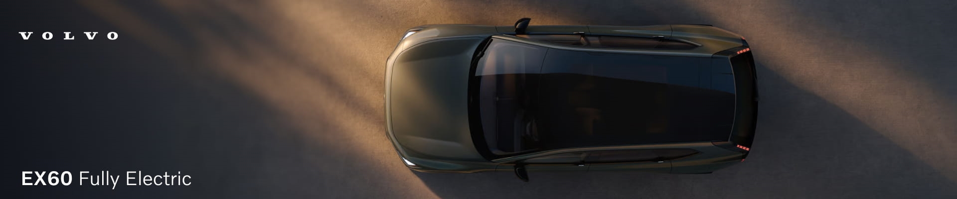 Volvo EX60 Fully Electric shown from an overhead view with a panoramic roof and dramatic lighting.