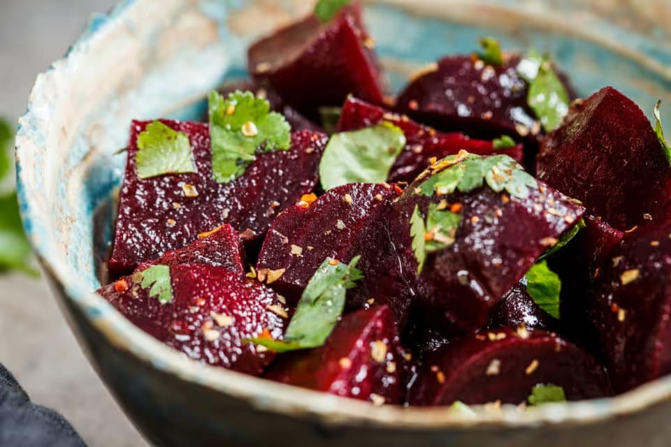 A bowl of beet salad with cilantro.