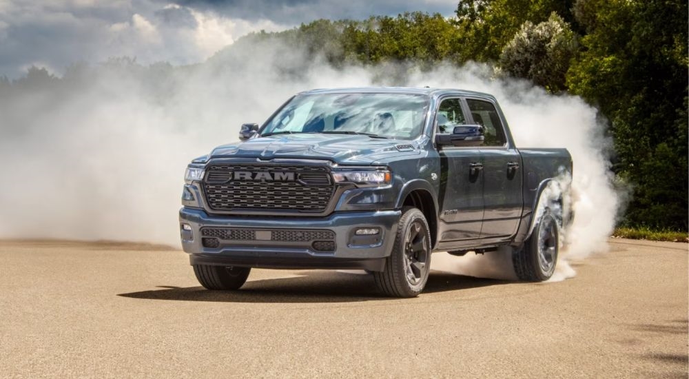 Grey 2026 Ram 1500 driving off-road and sending up dust.