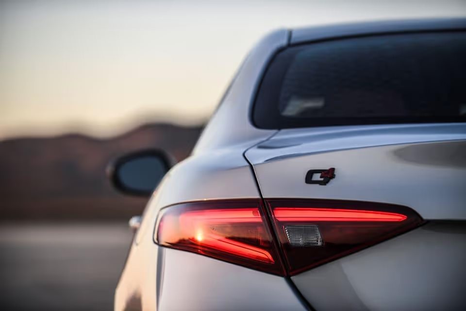 A closeup photo of a silver Alfa Romeo TI Sport the left rear tailight