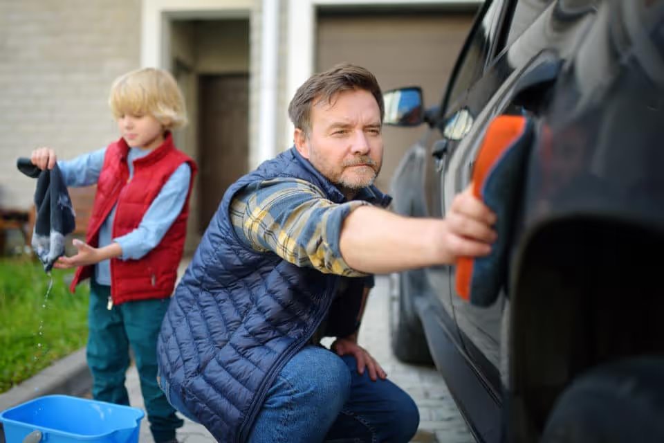 Dad and son washing car in the winter together