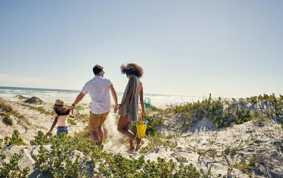 Family headed to the beach with a bucket of toys