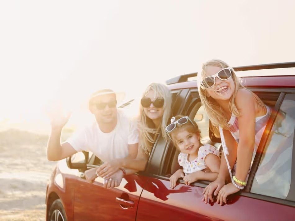 Family smiling at a pitstop during their road trip